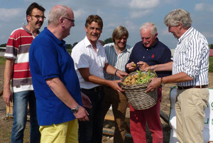 Wethouder Sijbom overhandigt de eerste oogst.